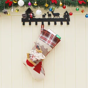 Botte de Noël Père Noël 3D avec détails à carreaux suspendue sur un mur en bois décoré