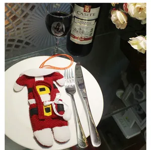 Close-up of Santa Claus overall knit cutlery holder on a plate for Christmas dining decor