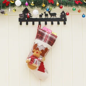 Chaussette de Noël avec poupée renne 3D et motif à carreaux sur un mur de fête décoré