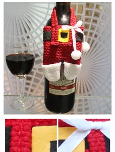 Close-up of red knitted Christmas wine bottle cover in overall pants style with bows