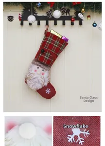Detail eines roten karierten Weihnachtssöckchens mit Weihnachtsmann und Geschenkkartons