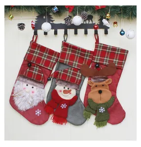 Detail von Weihnachtsstrümpfen mit Weihnachtsmann und Schneemann vor Holzwand