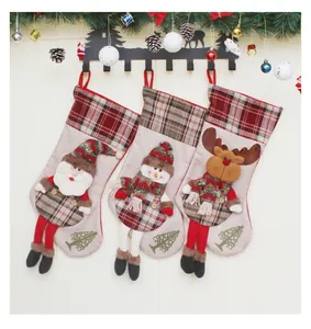 Tre calze di Natale con Babbo Natale, pupazzo di neve e renna su un supporto