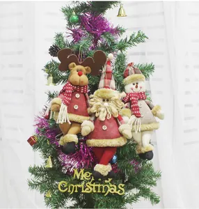 Close-up of reindeer, Santa, and snowman plush ornaments hanging on a Christmas tree