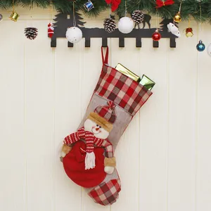 Christmas stocking with 3D snowman and plaid design hanging on a rustic wooden wall