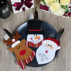 3-delige kerstbestekhouder set met kerstman, sneeuwman en rendier op een zwart dinerbord