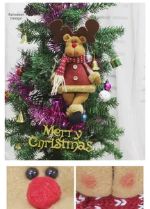 Detail of plush Christmas reindeer ornament with red plaid jacket and scarf on tree