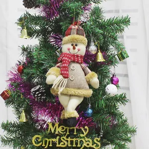 Plush snowman Christmas ornament with red plaid hat hanging on decorated tree