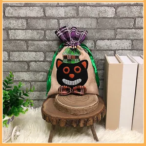 Detailed close-up of a burlap Halloween gift bag with a black cat embroidery and purple trim