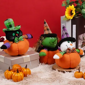 Trois peluches de citrouille d'Halloween avec chat noir et sorcière sur fond rouge