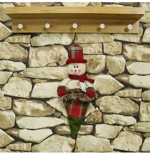 Detail view of a plush snowman Christmas ornament with red plaid hat on a wooden hook