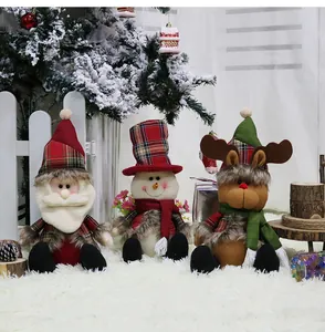 Three plush Christmas dolls featuring Santa, Snowman, and Reindeer in festive plaid outfits