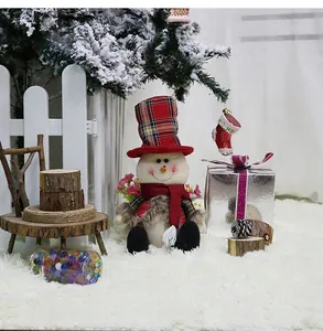 Close-up of a Christmas snowman plush doll with a red plaid hat and cozy scarf decoration