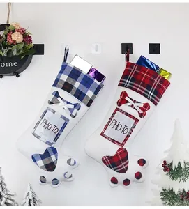 Detail of paw-shaped Christmas stockings with plaid patterns and photo slots on a wall