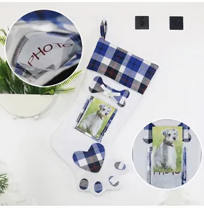 Detail of dog paw Christmas stocking with photo slot and blue plaid hanging on wall