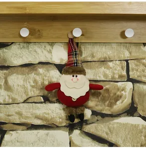 Dettaglio di Babbo Natale in peluche con cappello scozzese e bottone in legno decorativo