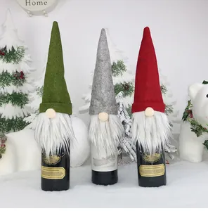 Close-up of three festive Christmas gnome wine bottle covers in red, green and grey colors