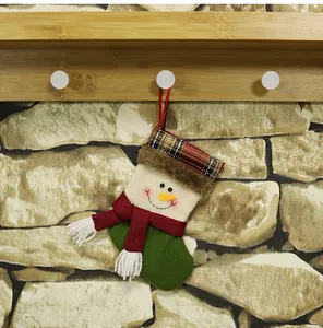 Detail of a hanging snowman Christmas stocking with festive red and green plaid patterns