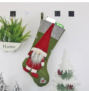 Detail eines grünen Filz-Weihnachtssockens mit 3D-Gnom-Puppe und grauem Herz-Patch