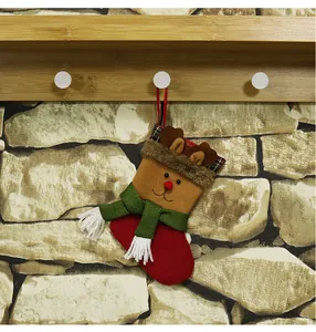 Close-up of reindeer Christmas stocking gift bag hanging on a rustic wooden hook