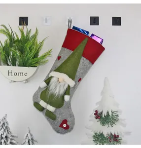 Details eines Weihnachtsstrumpfs mit grünem Gnom-Dekor und grauem Filzgewebe