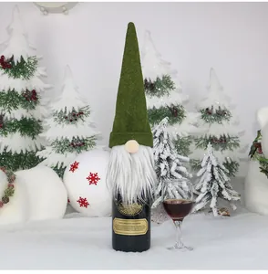 Close-up of a festive green felt gnome wine bottle cover with a long white beard and nose