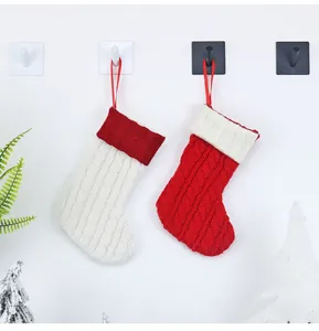 Detail von rot-weißen Strick-Weihnachtssocken mit Zopfmuster und praktischer Aufhängeschlaufe
