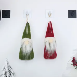 Detail of red and green Christmas gnome ornaments with long white beards on hooks