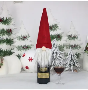 Detail of red gnome wine bottle cover with white beard and festive snowy background