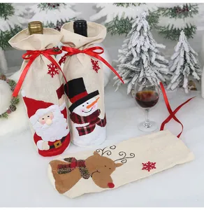 Dettaglio di copribottiglie in juta con motivi di Babbo Natale, pupazzo di neve e renna di Natale