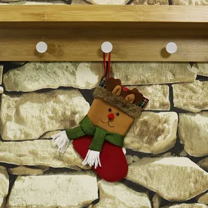 Classic Christmas reindeer stocking with red nose and green scarf hanging on a wooden hook