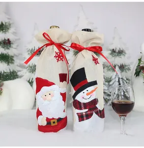 Dettaglio copribottiglie in lino con Babbo Natale e pupazzo di neve festivi