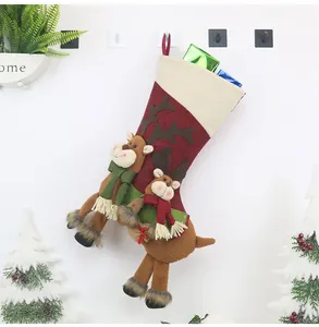 Detail view of 3D plush reindeer on burgundy Christmas stocking hanging on wall