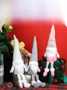 Detail of three long-legged Christmas gnomes in white, pink, and grey knit hats