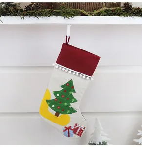 Detailed view of a Christmas stocking with tree embroidery and plush red cuff decoration