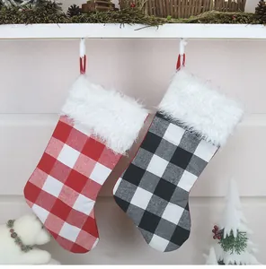 Chaussettes de Noël classiques à carreaux rouges et noirs suspendues à la cheminée