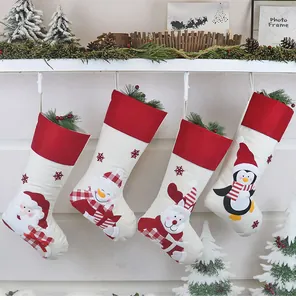 Dettaglio di calze natalizie con ricami di Babbo Natale e renne appese a un supporto