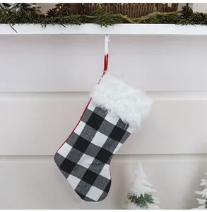 Détail d'une chaussette de Noël à carreaux buffalo avec bordure en fausse fourrure