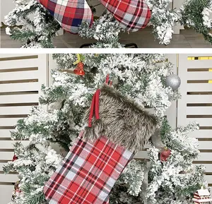 Detail of red and black plaid Christmas stocking with faux fur trim hanging on tree