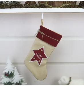 Dettaglio della calza di Natale in juta con polsino in maglia rossa e toppa a stella