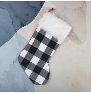 Détail d'une chaussette de Noël à carreaux noirs et blancs avec bordure en peluche