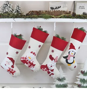Set di quattro calze natalizie con Babbo Natale e renne su un caminetto festivo