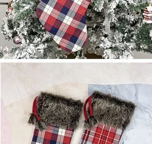 Detail of Christmas stocking with plaid fabric, faux fur cuff and decorative pom-poms