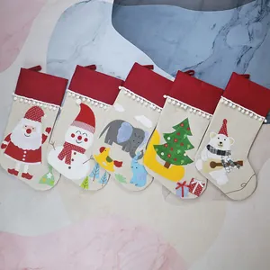 Set of 5 linen Christmas stockings with plush pom poms and holiday character patterns