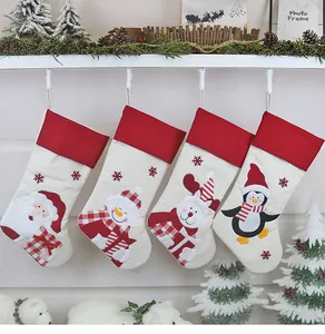 Dettaglio di quattro calze di Natale con ricamo di Babbo Natale e pupazzo di neve sulla mensola