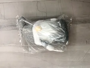 Detail of gray Nordic Christmas gnome plush doll in protective clear plastic packaging