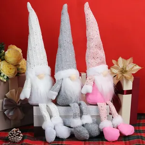 Three plush Christmas gnomes with sequin hats and long legs on a festive red background