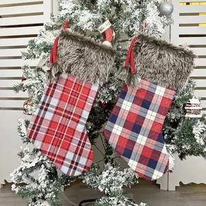 Classic plaid Christmas stockings set with faux fur trim hanging on a snowy Xmas tree