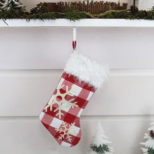 Detail of red buffalo plaid Christmas stocking with plush cuff and snowflake patches