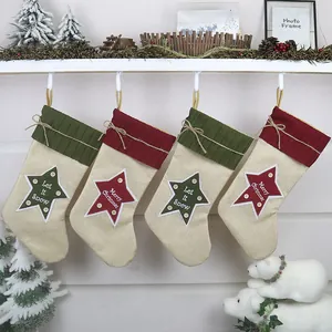 Set di quattro calze natalizie rustiche in juta con stelle su uno scaffale decorato
